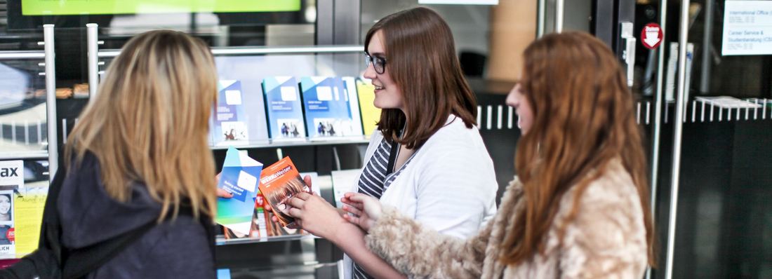 Three students get information at the Service Point