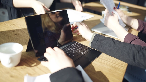 Studentin sitzt vor einem Laptop, ihr Gesicht spiegelt sich im Gerät