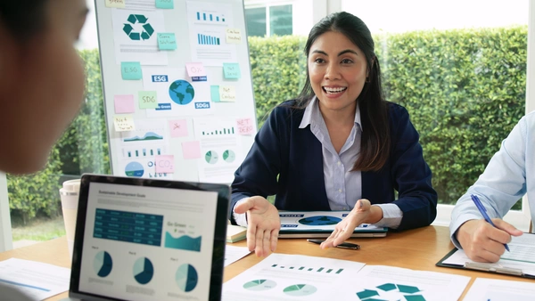 Zwei Frauen an einem Tisch, Flipcharts, Laptops, Thema ESG, CO2-Kompensation