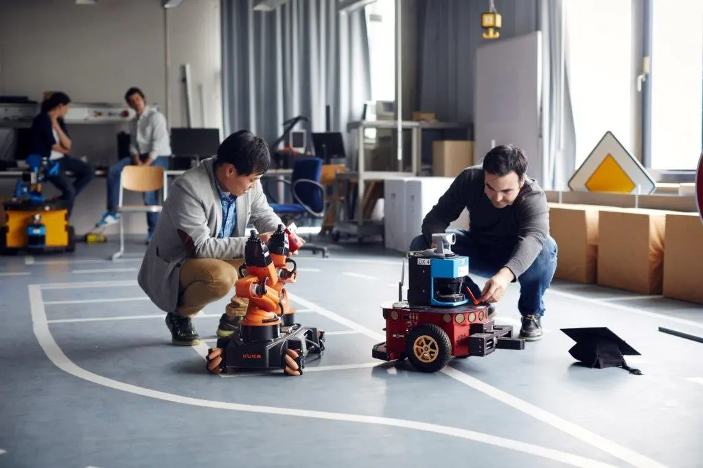 Zwei Promovierende testen im Labor für Robotik zwei Roboter.