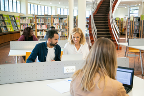 Menschen sitzen in einer Bibliothek