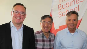 Three men in front of a white wall