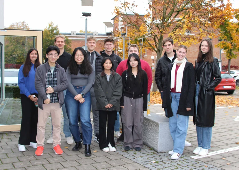 Eine Gruppe von 12 Personen lächelt in die Kamera.