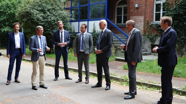 Landrat Peter von der Grün, Staatsminister Bernd Sibler, Thomas Sendtner (Staatliches Bauamt Ingolstadt), MdL Matthias Enghuber, Prof. Dr. Walter Schober (Präsident der THI), Oberbürgermeister Dr. Bernhard Gmehling, MdB Dr. Reinhard Brandl vor dem Gebäude 6 in Neuburg, das zuerst saniert und im WS 21/22 bezogen werden wird. Quelle: THI