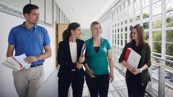 Studierende und Professorin sprechen miteinander.